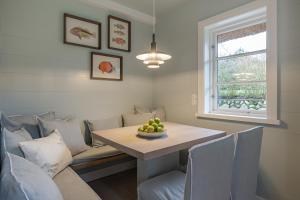a dining room with a table and chairs and a window at Kampens Herzstück in Kampen