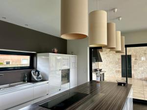 une cuisine avec des armoires blanches et un comptoir dans l'établissement Villa De L'Amiral - LUXE ET DETENTE A POMMEVIC, à Pommevic