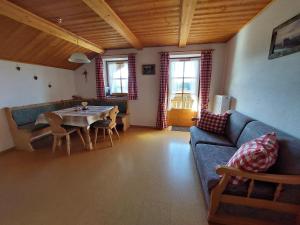 a living room with a blue couch and a table at Wörle, Ferienhof in Halblech