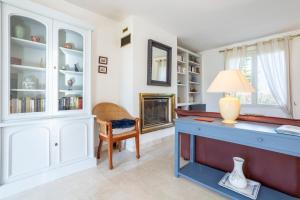 a home office with a blue desk and a fireplace at Ty Mamm, 5 min plage, 3 chb in Le Guilvinec