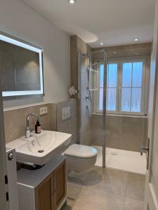 a bathroom with a sink and a toilet and a shower at Ferienwohnungen Bohner/Wohnung Elisabeth in Meersburg +40 photos