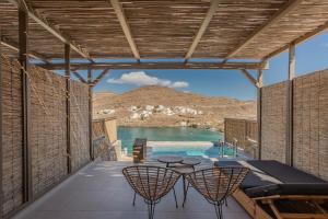 a patio with a table and chairs and a pool at Amal Kythnos Suites in Kithnos