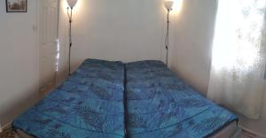 a bed in a corner of a room with two lamps at Tiny House 1, 2 ou 3 personnes SoeursGrises Béziers Centre Historique coeur de l'Hérault Occitanie, plus vieille ville de France, chemin de Compostelle à pied ou velo, passeport du pèlerin 24h, petits dejeuners et repas, 300m du centre ville in Béziers