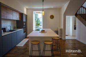 una cocina con encimera blanca y taburetes en Villa de Plaisance, en Limoges 17 fotos más