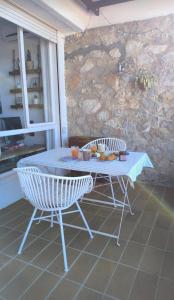 a table and chairs in a room with a stone wall at Estudio vistas al mar y a 5 minutos playa Estartit in L'Estartit