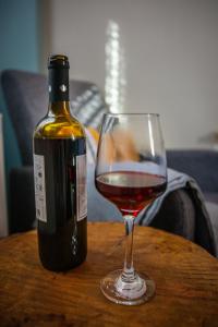 a bottle of wine and a glass on a table at Oreades Guesthouse in Koukouli