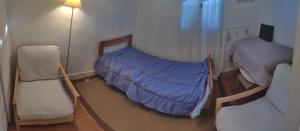 a room with two beds and two chairs in it at Tiny House 1, 2 ou 3 personnes SoeursGrises Béziers Centre Historique coeur de l'Hérault Occitanie, plus vieille ville de France, chemin de Compostelle à pied ou velo, passeport du pèlerin 24h, petits dejeuners et repas, 300m du centre ville in Béziers