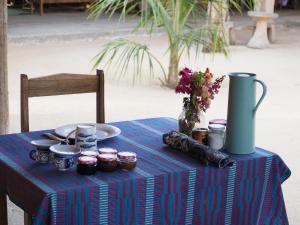 a table with a blue table cloth on a table with a vase at Nguel du Saloum - Chez Abdou et Mar in Mar Lodj