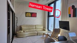 un soggiorno con divano e un cartello con la scritta Namwegian Tower di Euljiro Namsan Tower View a Seul