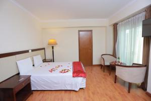 ein Hotelzimmer mit einem Bett, einem Schreibtisch und einem Tisch in der Unterkunft Atlas International Hotel in Addis Abeba