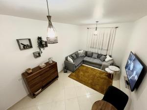 a living room with a couch and a tv at Appartement Kawacim in Tangier
