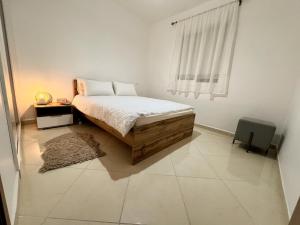 a white bedroom with a bed and a window at Appartement Kawacim in Tangier