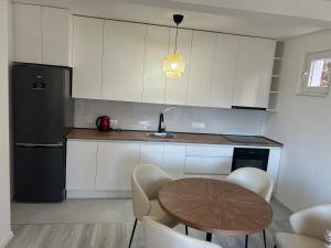 a kitchen with a table and a black refrigerator at Sweet Holiday 2 in Mostar +5 photos