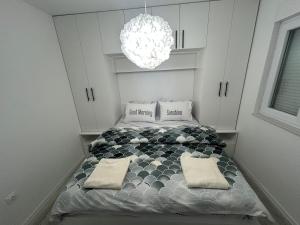 a bedroom with a bed with two pillows and a chandelier at Sweet Holiday 2 in Mostar