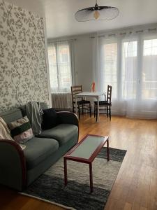 シャロン・シュル・ソーヌにあるCosy T2 centre-villeのソファとテーブルのあるリビングルーム