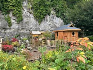 a small wooden house with a fence in a garden at Cascades Gardens in Matlock