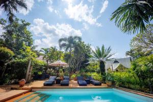 a swimming pool with lounge chairs next to a villa at 11 Rooms in Chiang Dao