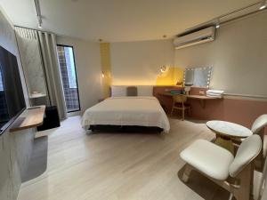 a hotel room with a bed and a desk and chair at 享兜兜 in Tainan