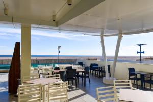a restaurant with tables and chairs and a view of the beach at Zenith Hotel in Mamaia