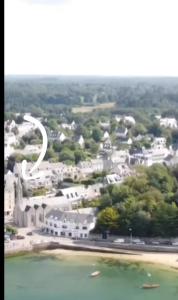 een luchtzicht op een groot wit gebouw naast het water bij Au coeur de la station balnéaire Au pied du port Bel Appartement contemporain Tout Équipé Lumineux et Calme Excellent emplacement in Bénodet +2 foto's