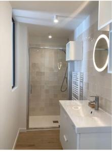 een badkamer met een douche, een wastafel en een wastafel bij Au coeur de la station balnéaire Au pied du port Bel Appartement contemporain Tout Équipé Lumineux et Calme Excellent emplacement in Bénodet