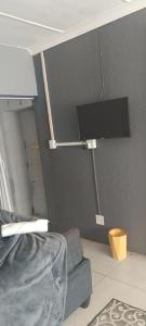 a room with a bed and a tv on a wall at Sunset Guest House in Roodepoort +30 photos