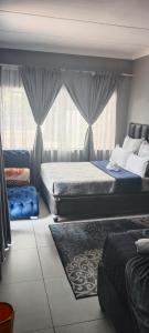 a bedroom with two beds and a window at Sunset Guest House in Roodepoort