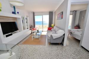 a living room with a couch and a television at Delta Muga Silvia in Empuriabrava