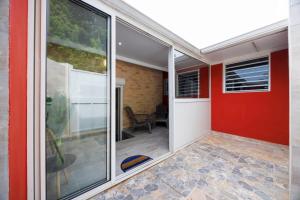 a sliding glass door of a home with a red wall at Villa Les Pierres Précieuses in Rémiré