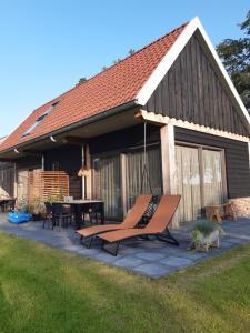 a patio with a hammock in front of a house at Het Bruineveld in Daarle