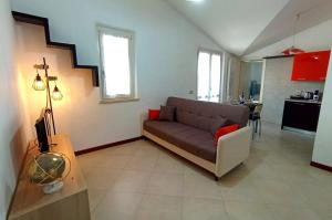 a living room with a couch and a kitchen at AlMa Apartament in Lucca