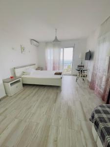 a large white bedroom with a bed and a wooden floor at Luka MonteVilla in Bar