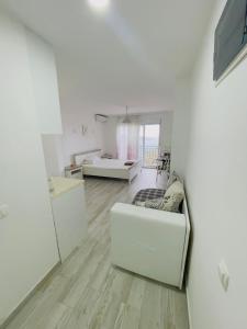a living room with white walls and wooden floors at Luka MonteVilla in Bar