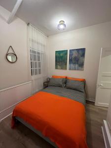 une chambre avec un lit avec une couverture orange dans l'établissement Cosy 1 Bed Flat in the Heart of Westminster, à Londres