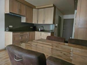 a kitchen with a large wooden table and chairs at Zeewind 1 Green Garden in Middelkerke