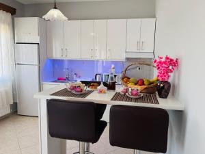 a kitchen with a table with a basket of fruit at Nefeli luxury apartment in Aronás +11 photos