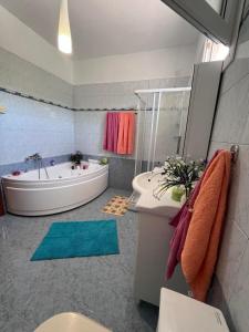 a bathroom with a tub and a toilet and a sink at Nefeli luxury apartment in Aronás