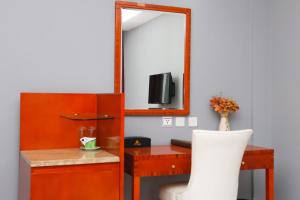 a room with a mirror and a desk and a chair at Sun Beach Hôtel in Cotonou
