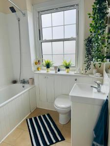 a bathroom with a toilet and a sink and a window at Beautiful Apartment on London Bridge! in London