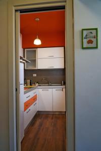 a kitchen with white cabinets and an orange ceiling at Attico in centro - "La Nica" in Catania