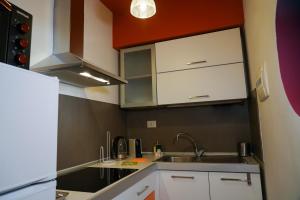 a kitchen with white cabinets and a sink at Attico in centro - "La Nica" in Catania