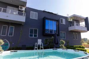 a house with a swimming pool in front of a building at Sunshine Apartments in Ulcinj