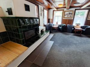 a waiting room with a fireplace and chairs and tables at Penzion Betlém in Janske Lazne
