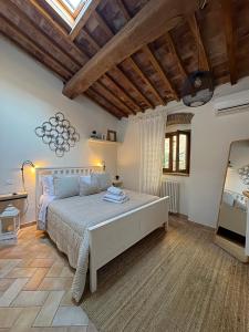a bedroom with a large bed in a room with wooden ceilings at Bouganville in Rosignano Marittimo