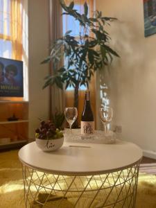a table with a bottle of wine and a bowl of fruit at Central Apartment In London Bridge! in London