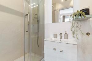 Un baño blanco con ducha y lavabo. en Foresteria Buenos Aires, en Milán 32 fotos más