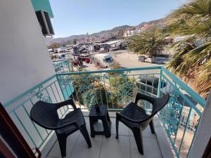 ein Balkon mit zwei Stühlen und Blick auf einen Parkplatz in der Unterkunft Foça Mint Hotel in Foça
