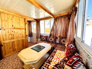 una camera con divano e tavolo in treno di Atlas Hostel Taghazout a Taghazout