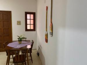 a dining room with a table and baseball bats on a wall at Eplantae - Cabo frio - RJ in Cabo Frio