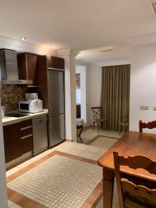 a kitchen and dining room with a table and a microwave at GAV Ciudad in Ronda